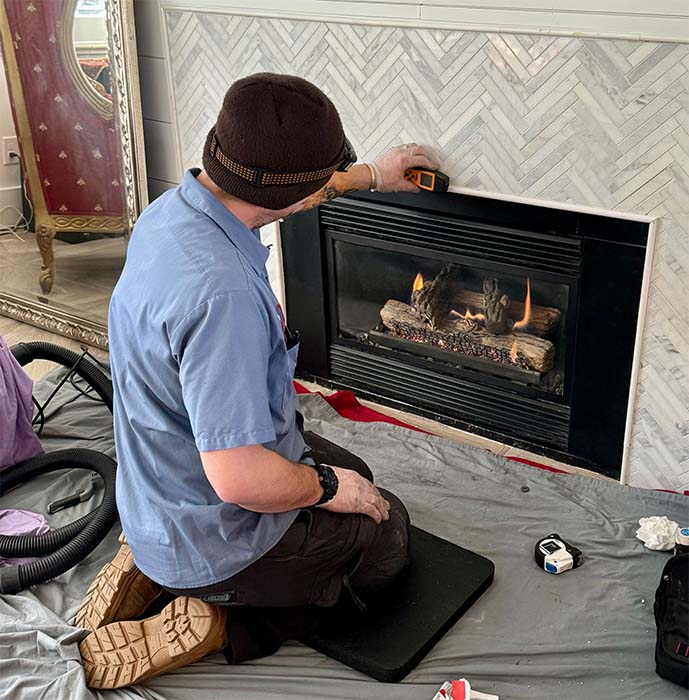 Mountain Man Original image of gas appliance repair Technician working on fireplace